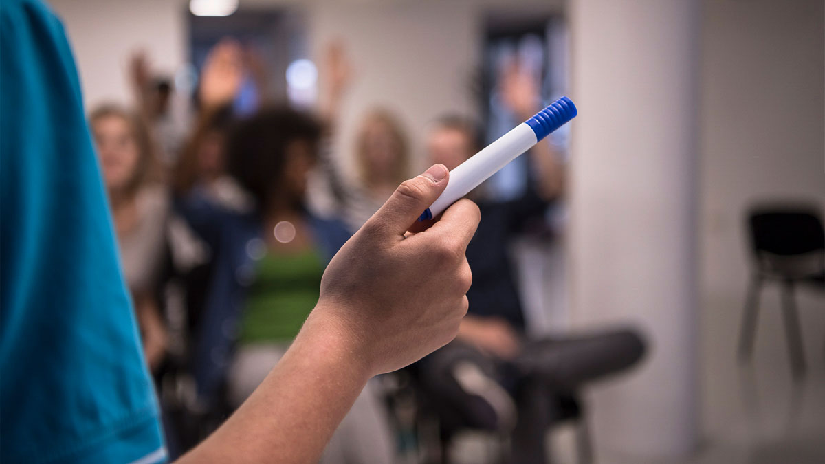 Lecturers hand holding a board pen