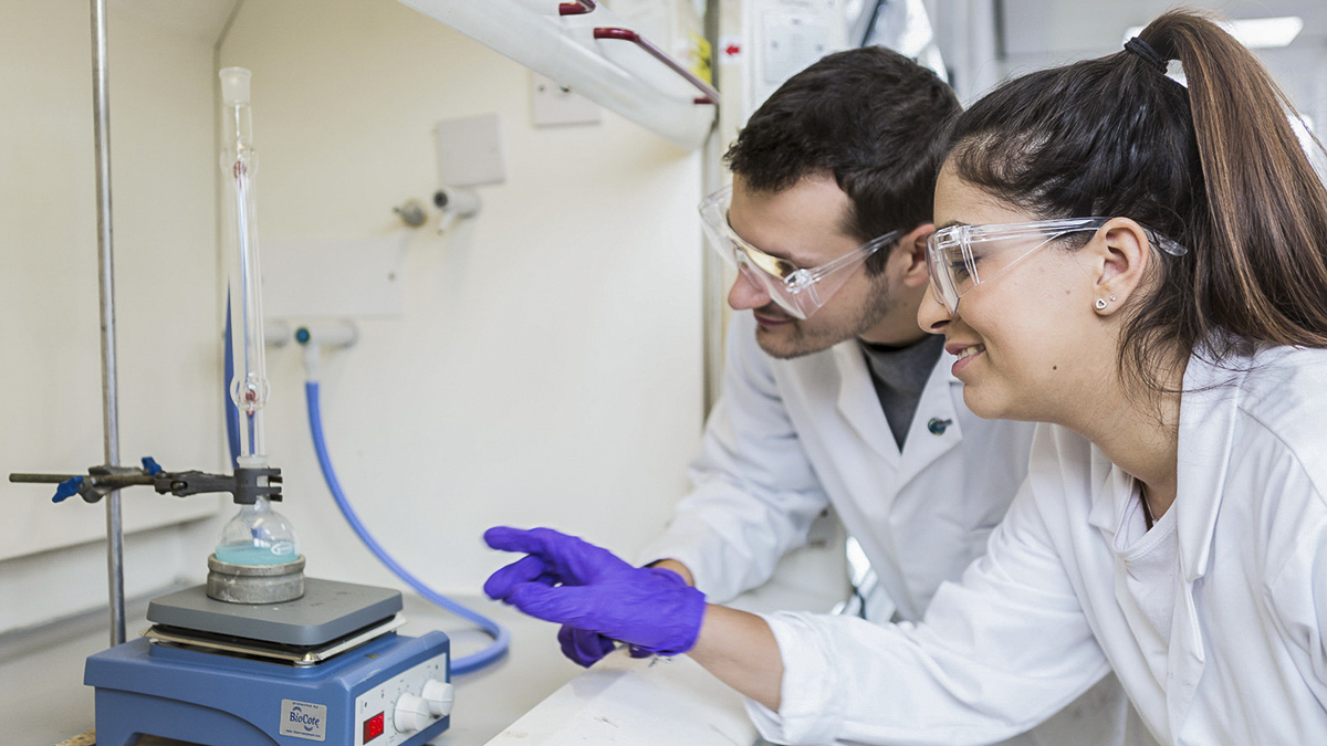 Two students smiling over an experiment