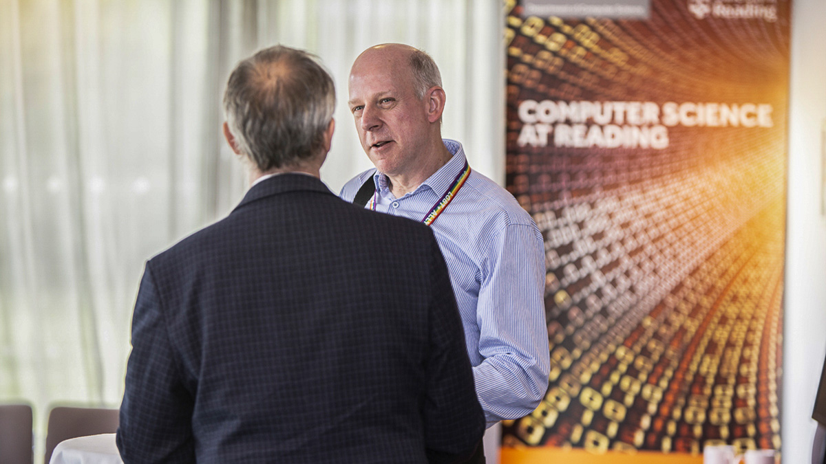 Two staff members from the Department of Computer Science talking to each other