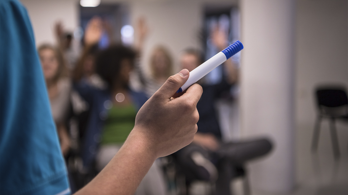 Close up of PhD student's hand pointing with a marker pen while giving a lecture